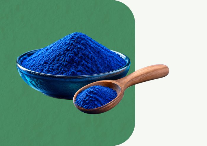 Phyco-Rich Spirulina Powder in glass bowl with blue powder and green spirulina